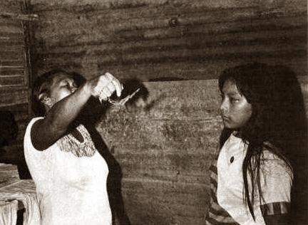 a woman shaman clearing energy from a young woman inside a wooden cabin