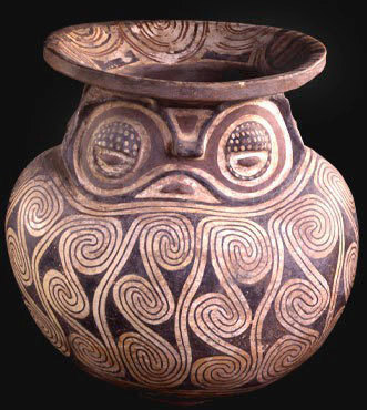 funerary urn with owl face and spiral patterns
