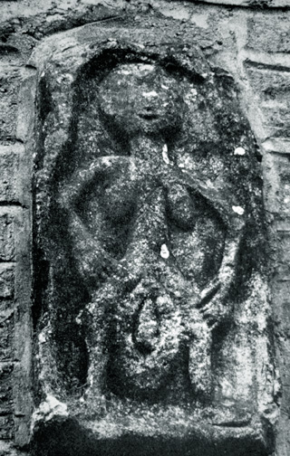 stone relief of woman holding huge vulva, on church wall