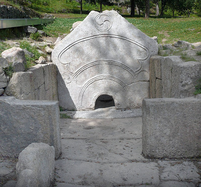 carved stone wall with low sauna entrace