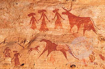 group of women with wide hair stand near bulls, arms outstretchedl