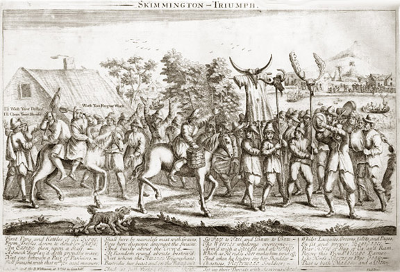 crowd of men parading a man with distaff through town