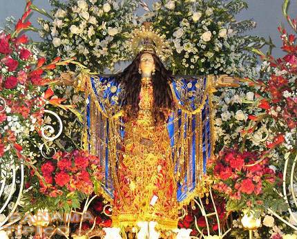 saint adorned with flowers and jewelry